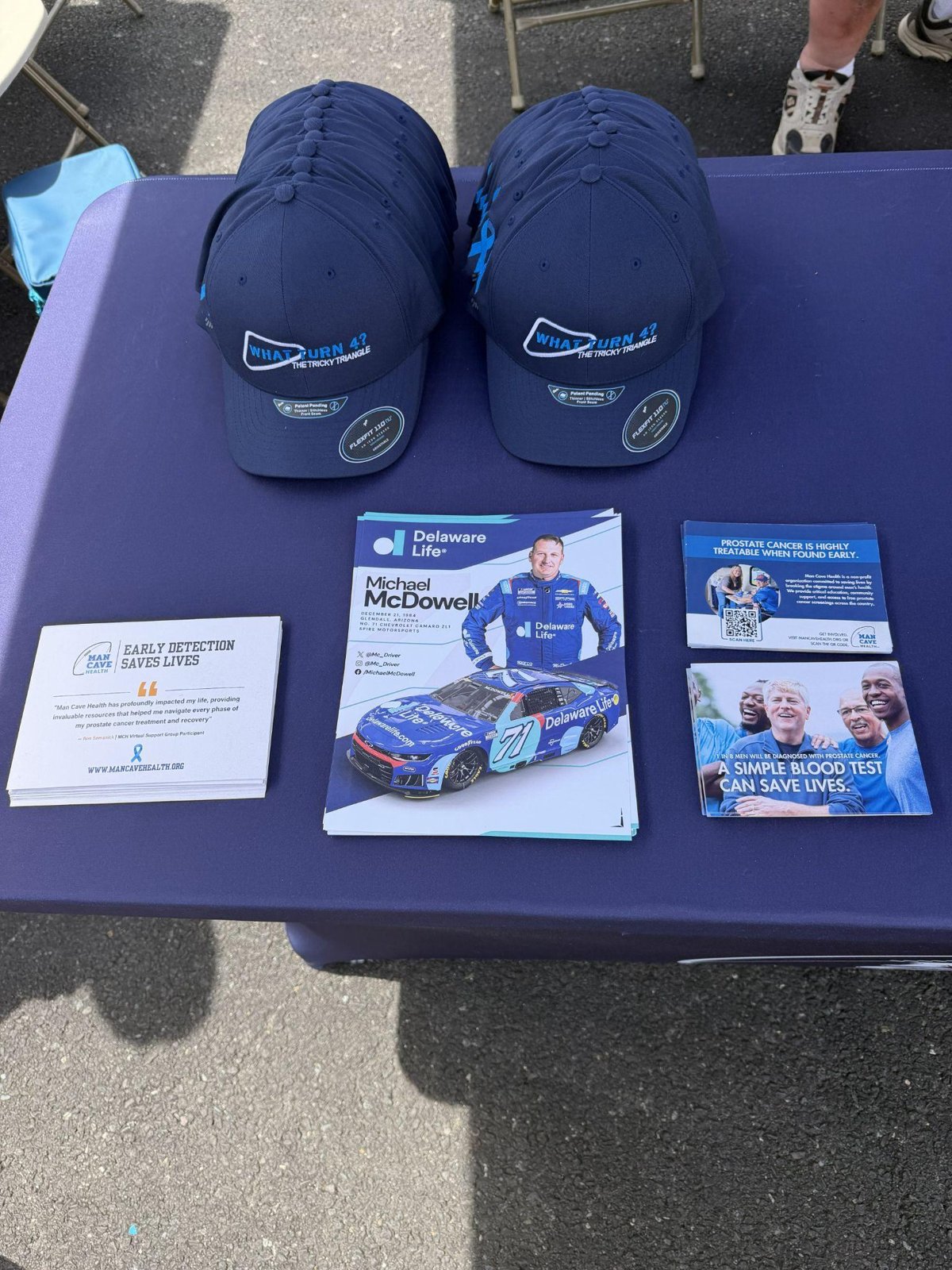 Man Cave Health caps and NASCAR driver Michael McDowell card at Pocono Raceway